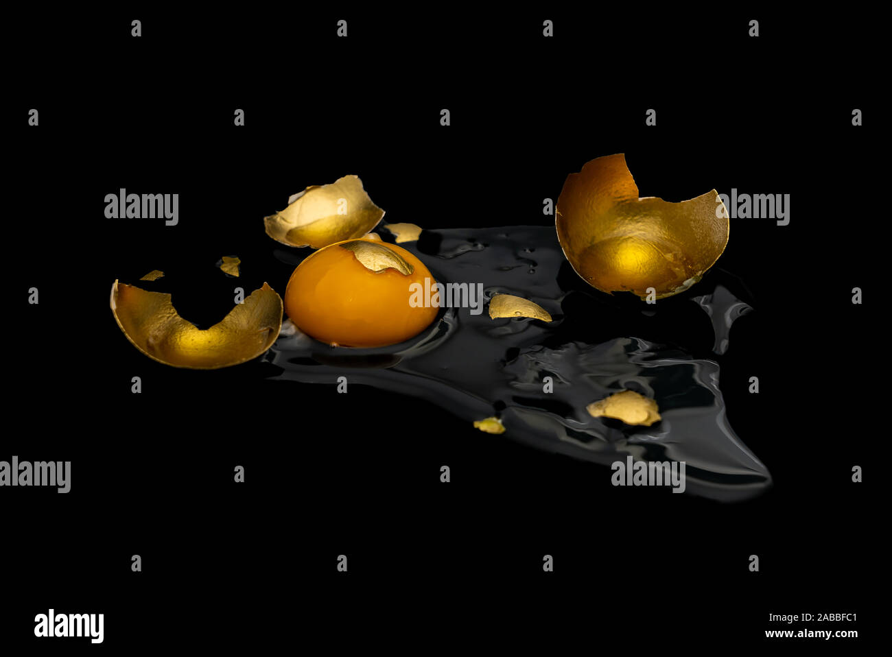 a broken Golden egg, the yolk and white of a chicken egg spread out on ...