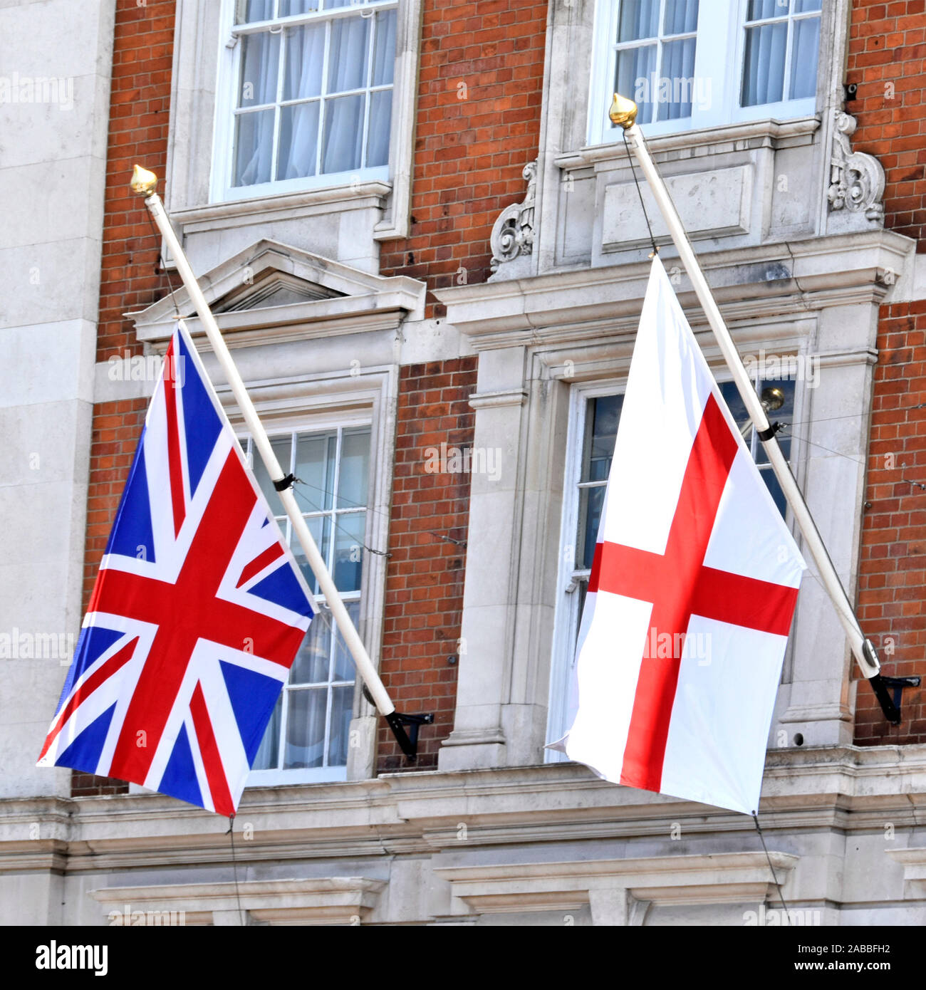 Displaying pristine British union jack flag of United Kingdom alongside National flag of England derived from Saint Georges Cross London England UK Stock Photo