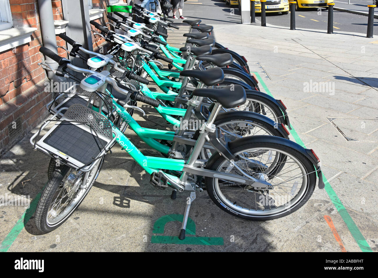 Row of green Beryl bikes for hire outside Bournemouth train station for railway passengers to use phone app & complete their journey Dorset England UK Stock Photo