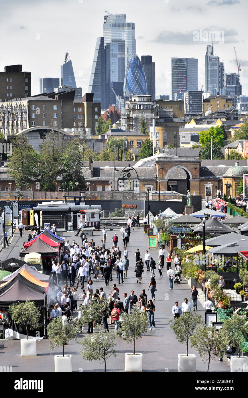 Aerial view Canary Wharf busy outdoor street food business stalls at West India Quay City of London cityscape skyline beyond East London Docklands UK Stock Photo