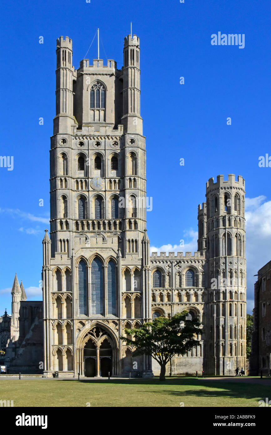 Ely cathedral building popular for historical & religion tourism visitors Norman West Tower from cathedral green Cambridgeshire East Anglia England UK Stock Photo