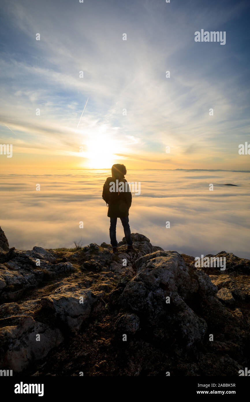Man on top of mountain watching the sunset Stock Photo - Alamy