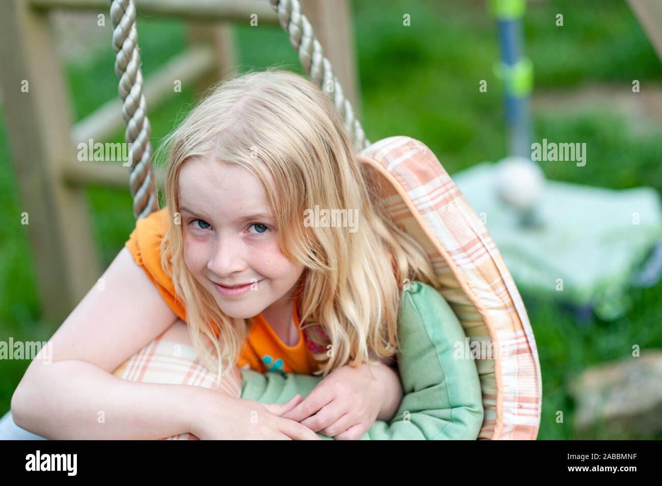 Headshot of pretty young blonde girl making eye contact and smiling Stock Photo