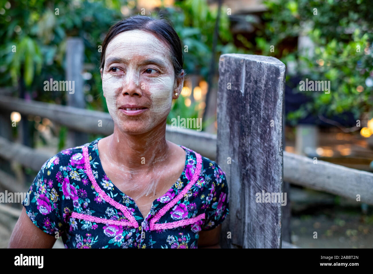 Young Burmese village woman with her face and neck painted with thanaka, a natural cosmetic and sunscreen on the Chindwin River, Myanmar (Burma) Stock Photo