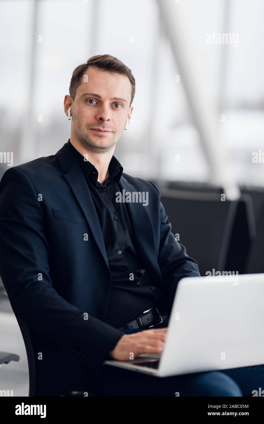Working on laptop in airport while waiting for flight Stock Photo