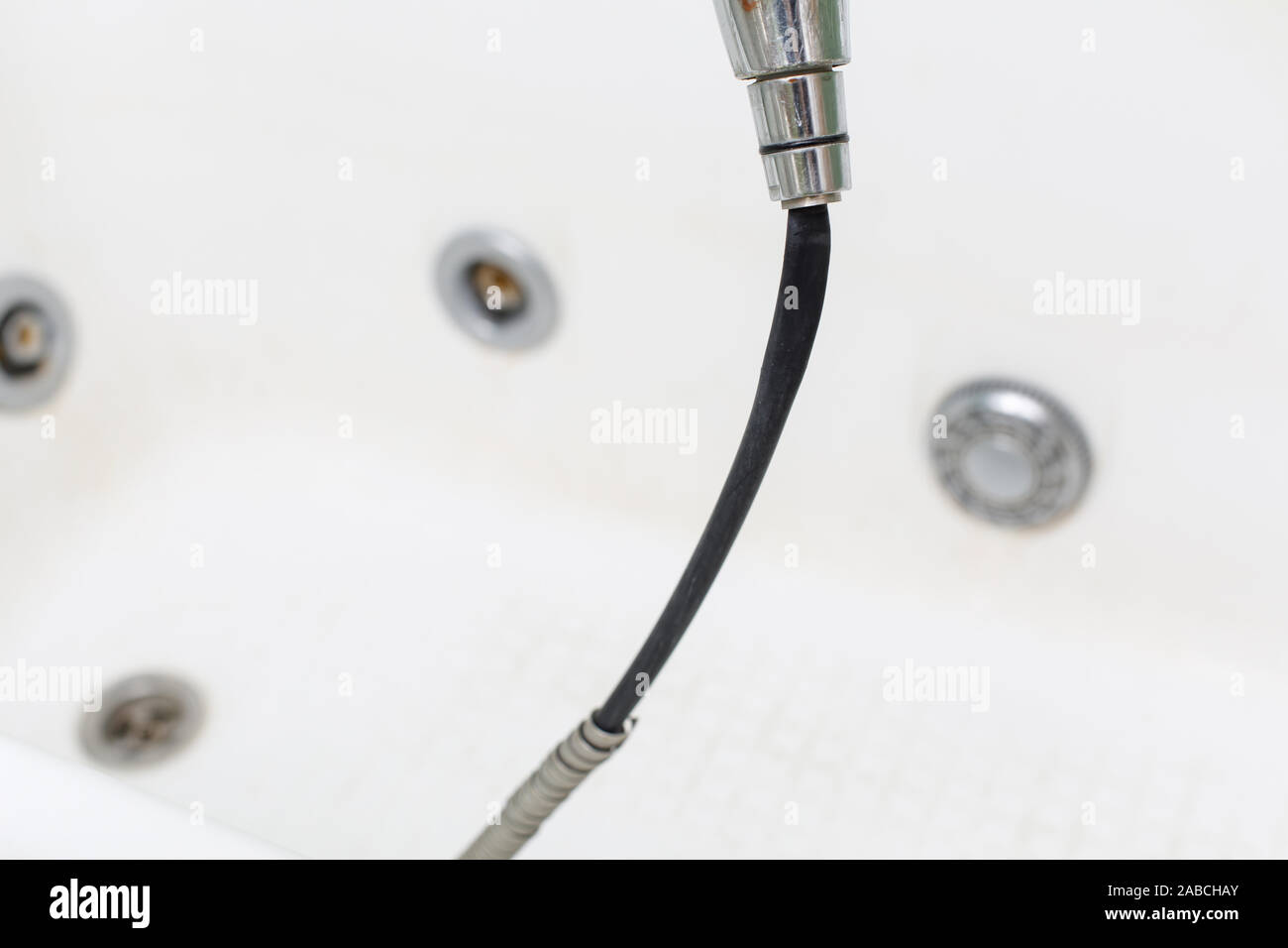 Old damaged leaking shower hose in the bathroom of house Stock Photo