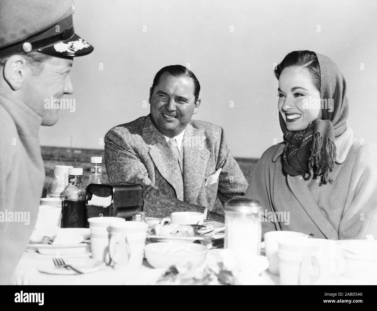 ONE MINUTE TO ZERO, from left: William Talman, producer Edmund Grainger, Ann Blyth having lunch on location, 1952 Stock Photo