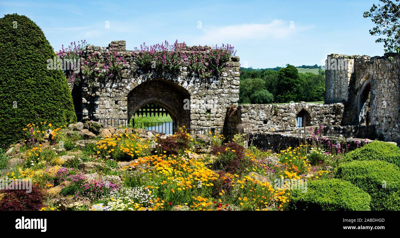 Leeds Castle barbican,  gate, mill ruins & summer garden. Portcullis / iron grille. Late Norman structure. River Len feeding the castle Lake and Moat. Stock Photo