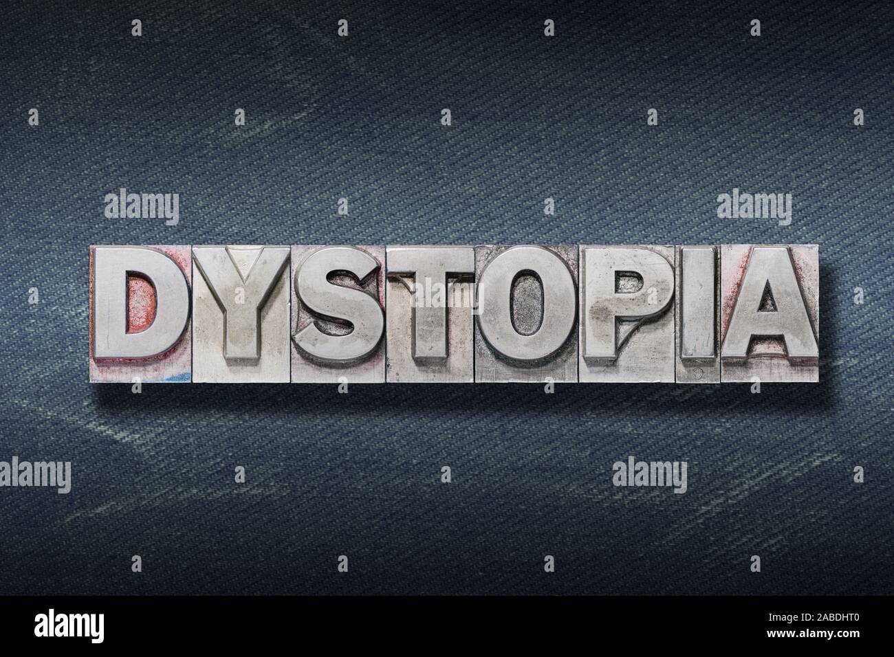 dystopia word made from metallic letterpress on dark jeans background Stock Photo
