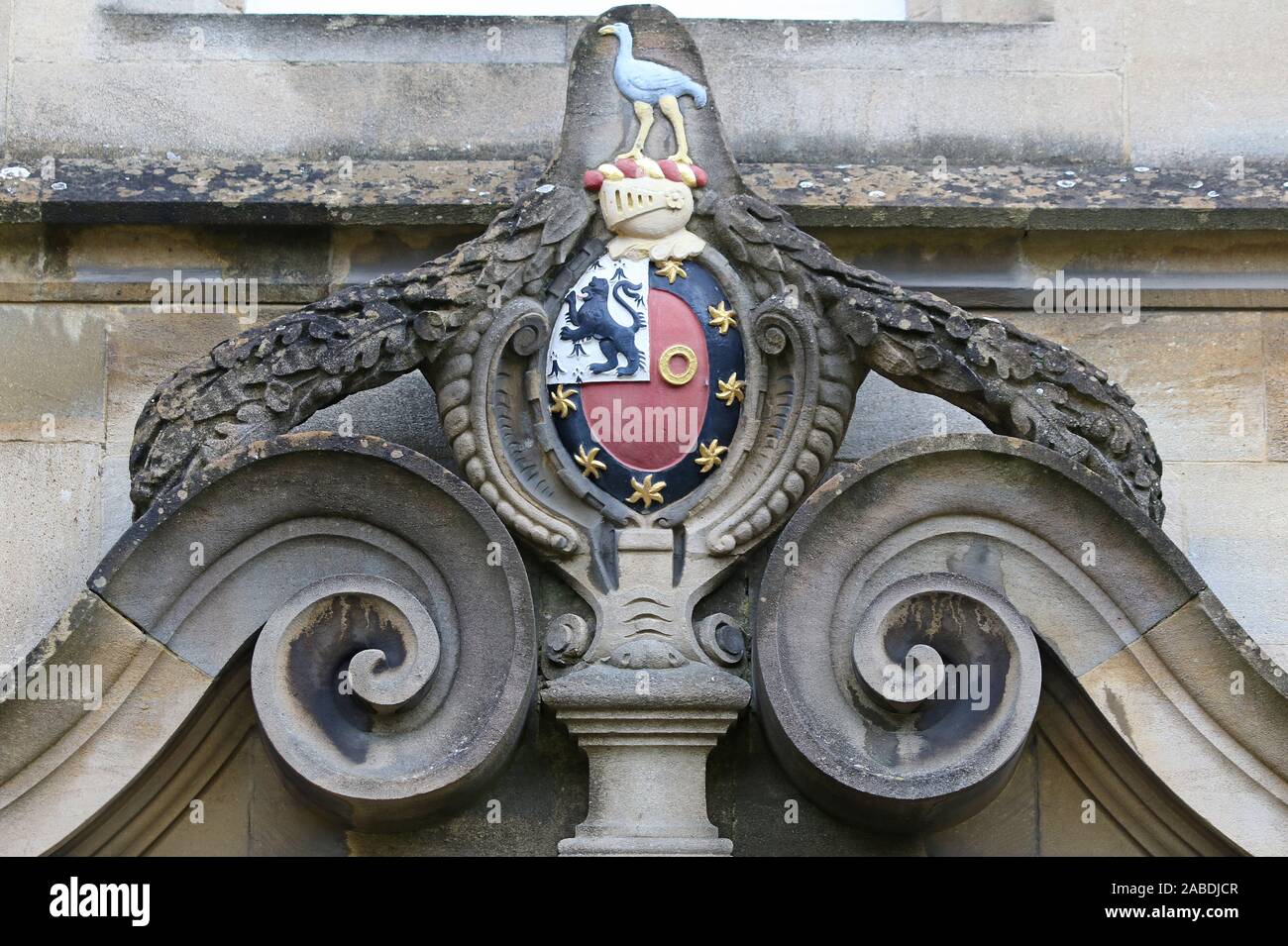Coat of arms of St John's College Oxford above a door in the front quad the bird is a stork and is Sir Thomas White's crest on a wreath and helmet Stock Photo