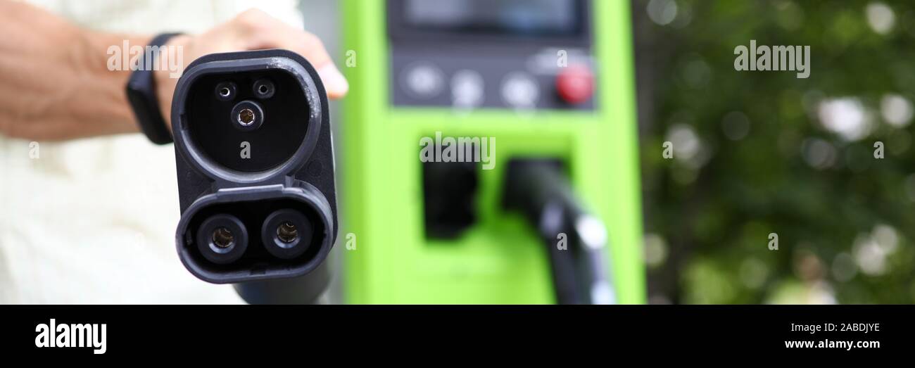 Man showing charging cord for eco cars Stock Photo Alamy