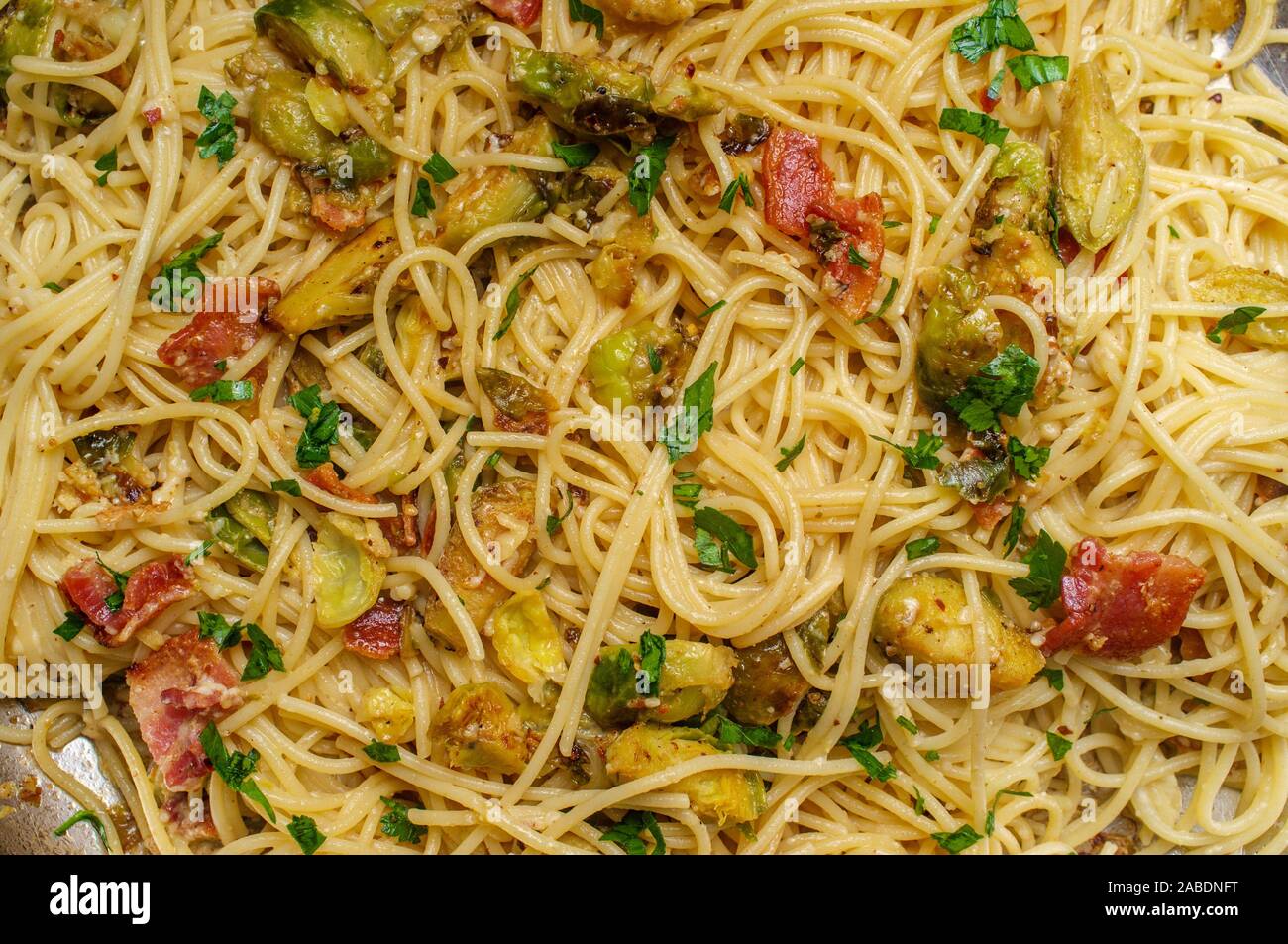 Cooking creamy Italian cuisine spaghetti alla carbonara with bacon and