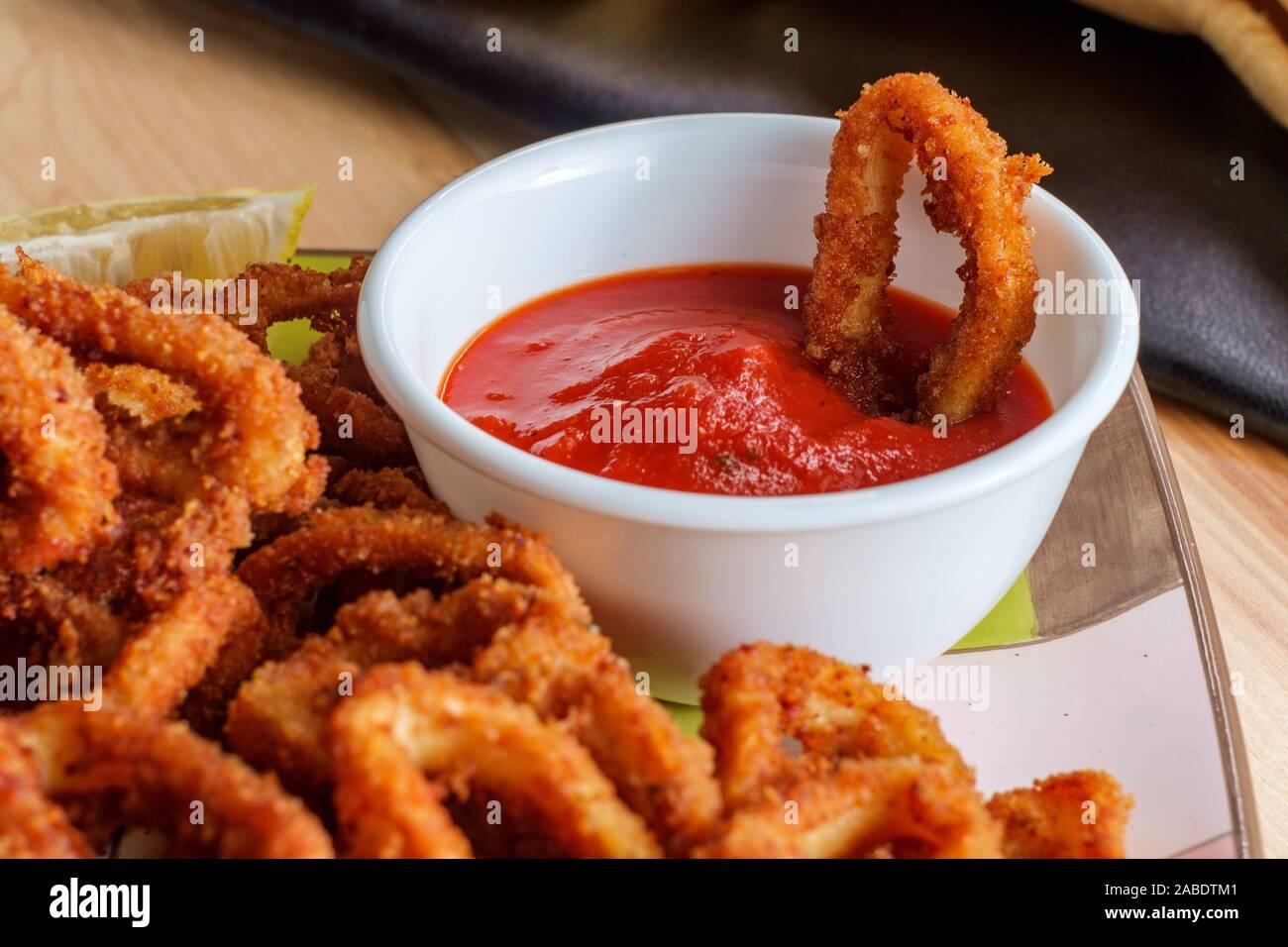 Plate of Italian crispy calamari rings appetizer with marinara tomato