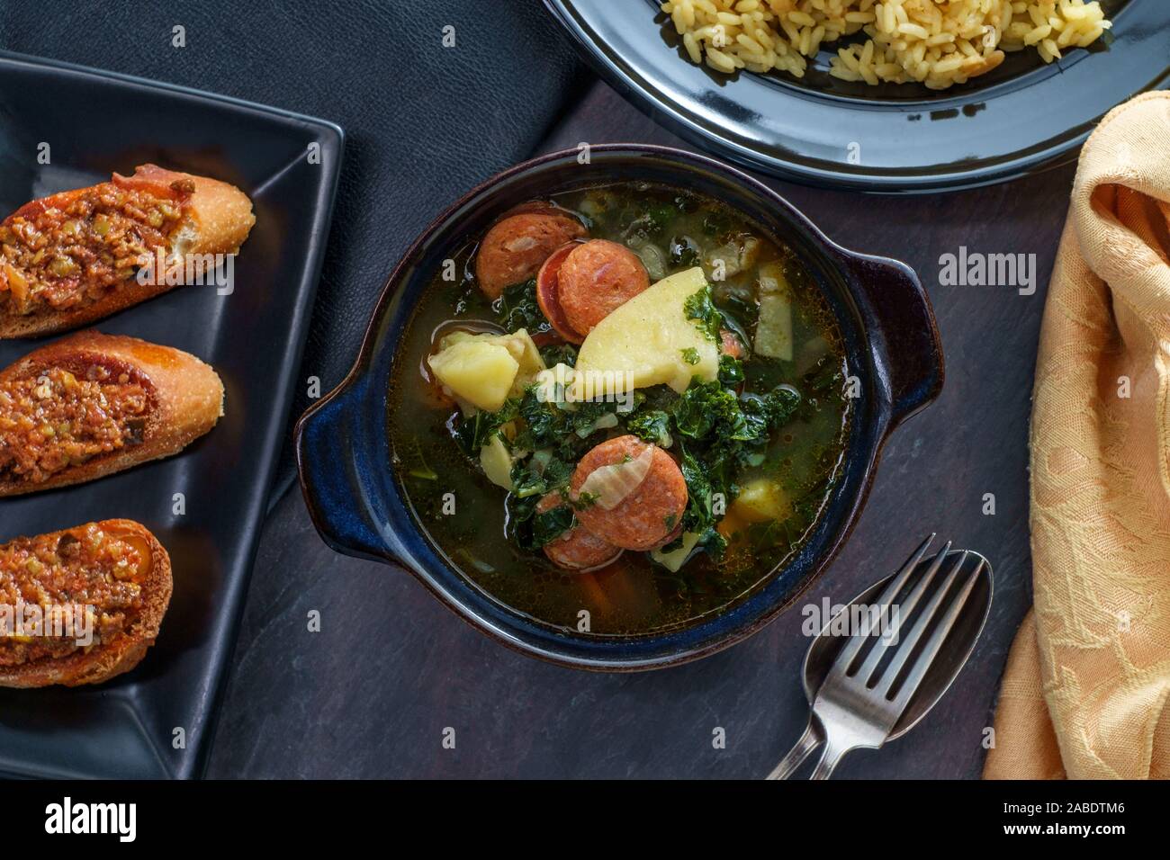 Traditional Portuguese caldo verde chourico soup with orzo rice pilaf and petiscos Stock Photo