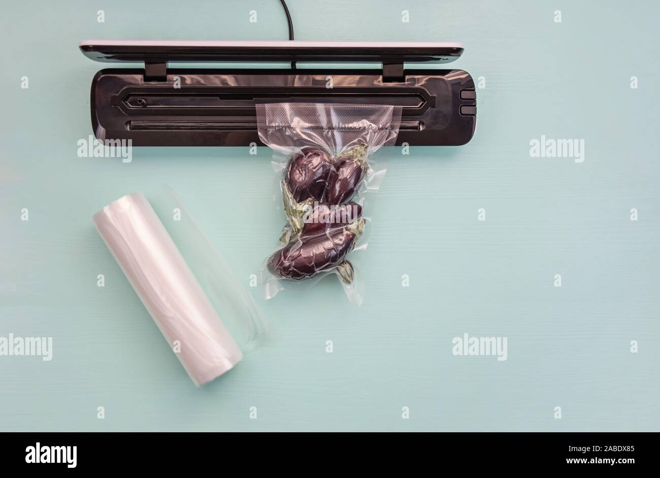 Plastic sealing machine. Vacuum packaging of fresh tomatoes. Vacuum