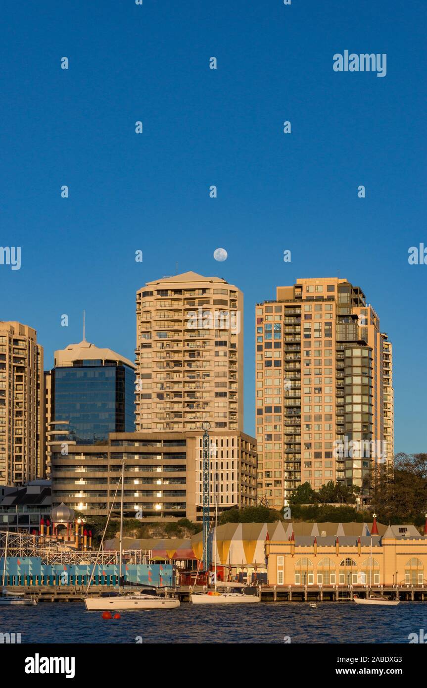 Milsons Point skyline ar golden hour wih full moon over buildings and Lavender bay with yachts . Sydney, Australia Stock Photo