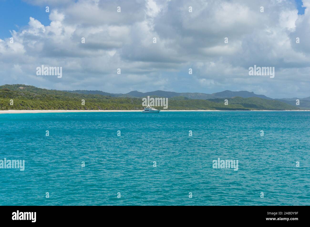 Cruise liner, ship in tropical sea with exotic island on the background. Whitehaven beach, Whitsundays, Queensland, Australia Stock Photo