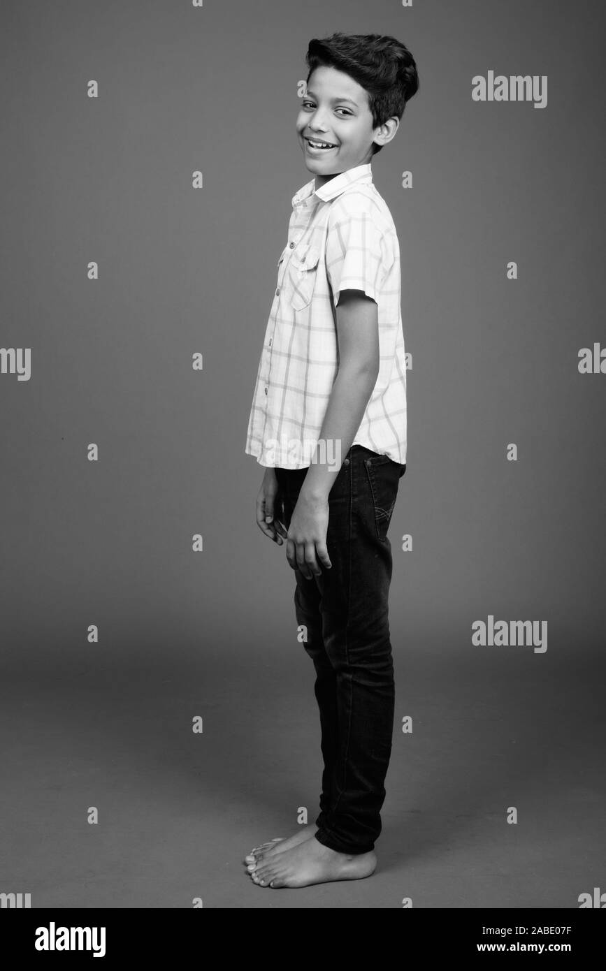Young Indian boy wearing checkered shirt against gray background Stock Photo