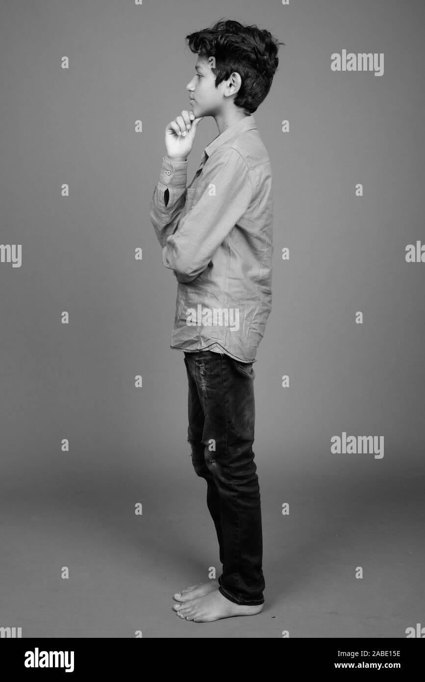 Young Indian boy wearing smart casual clothing against gray background Stock Photo