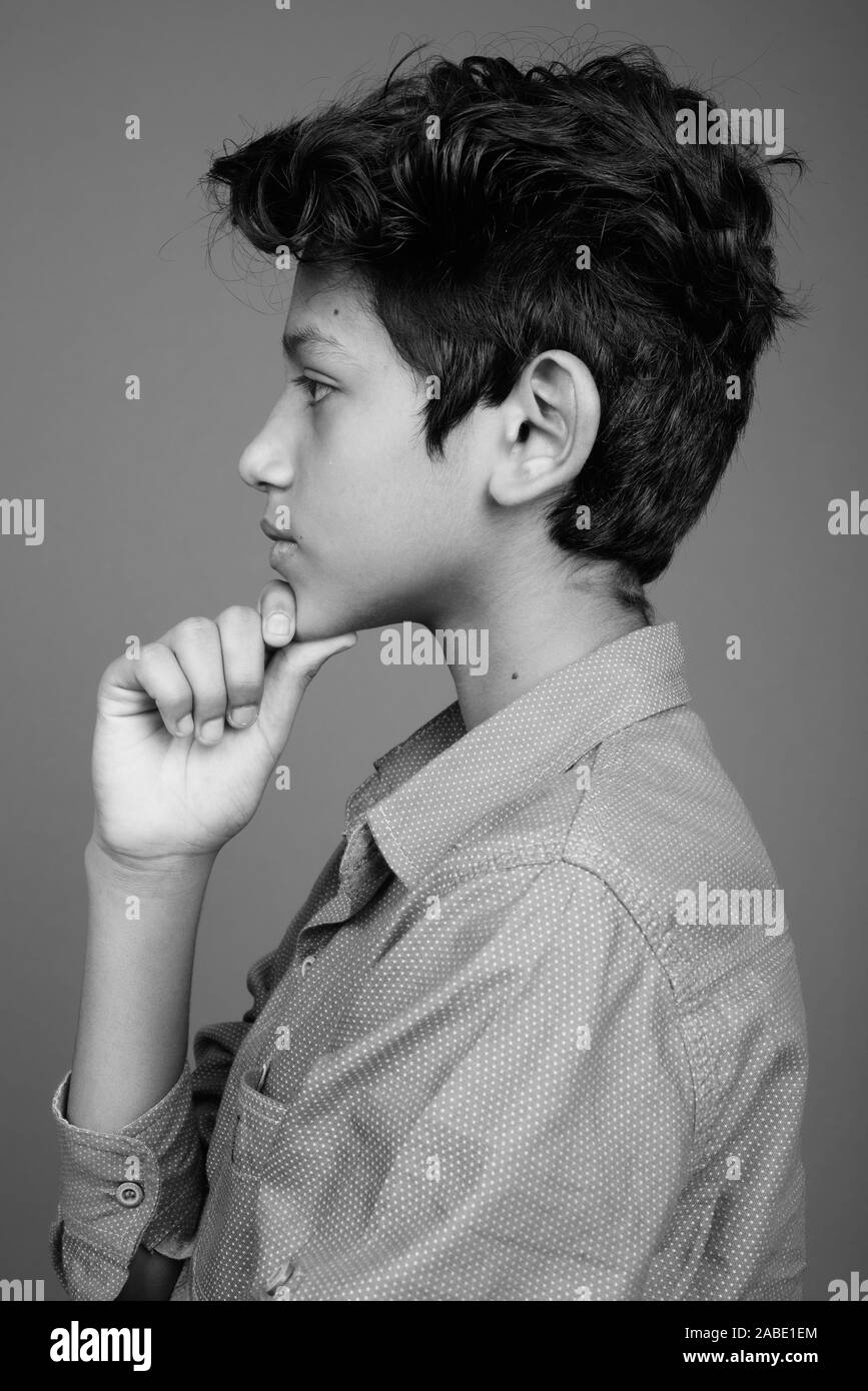 Young Indian boy wearing smart casual clothing against gray background Stock Photo