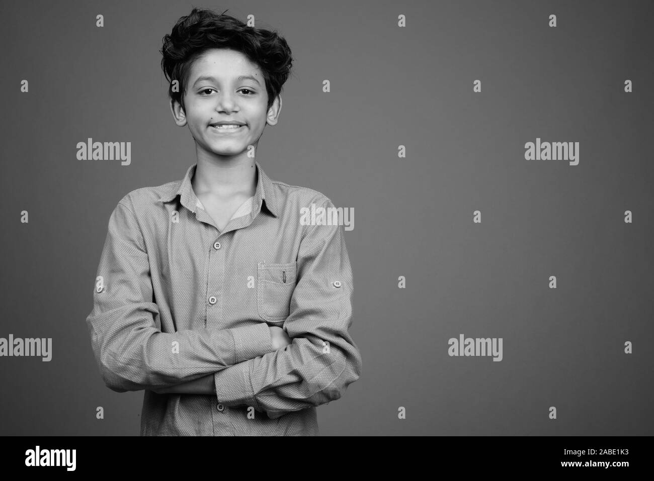 Young Indian boy wearing smart casual clothing against gray background Stock Photo