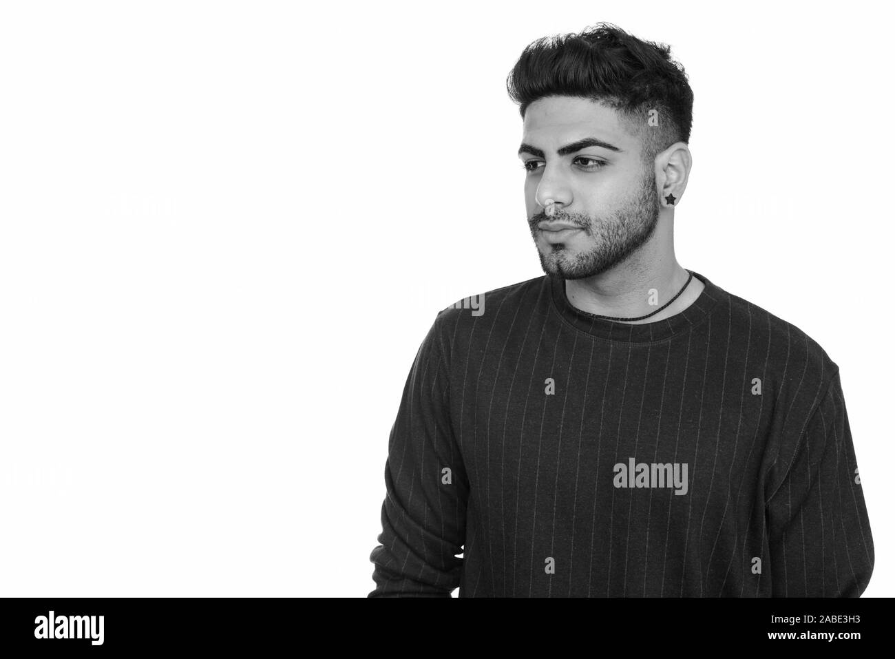 Studio shot of young handsome Indian man isolated against white ...