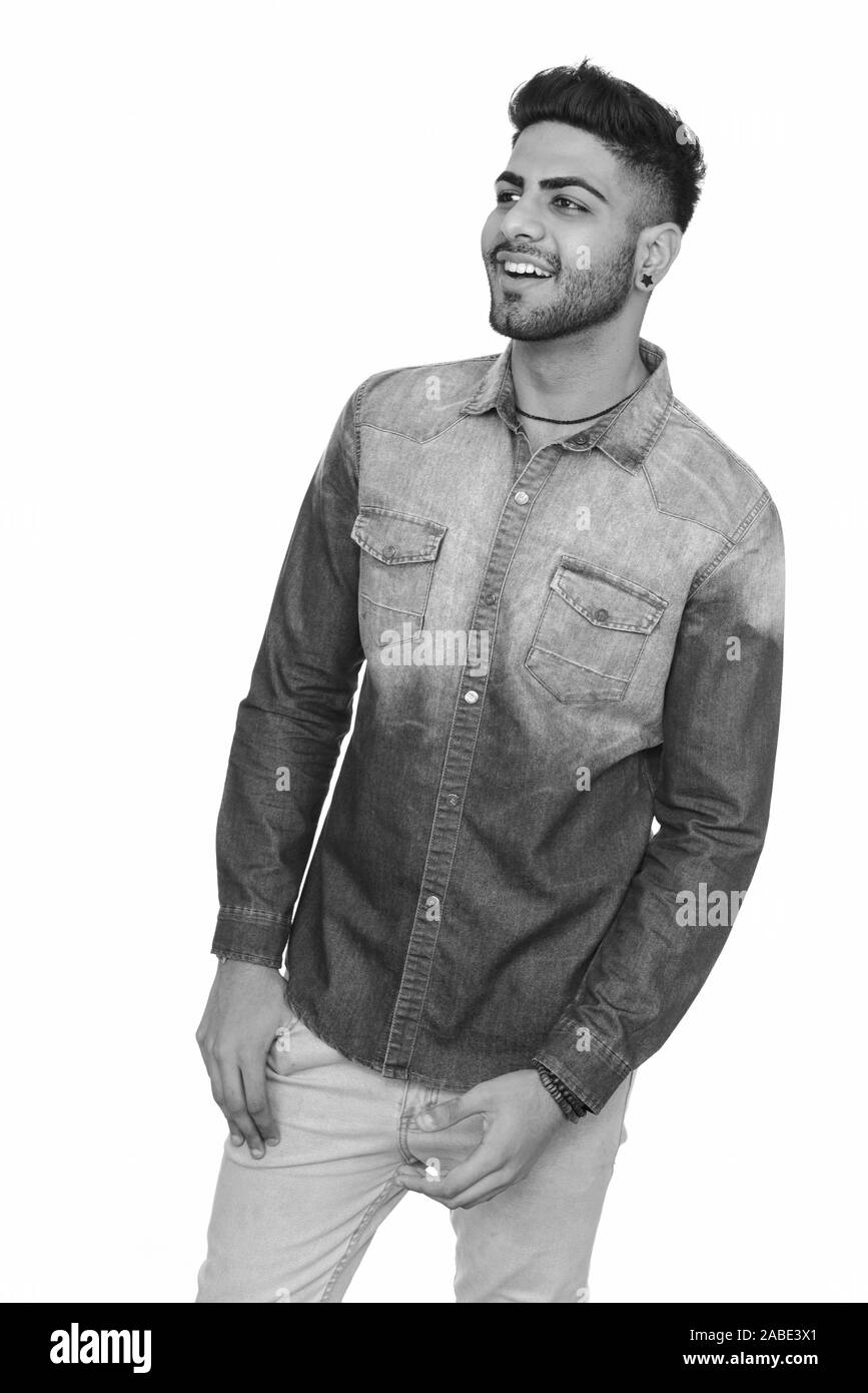 Studio shot of young happy Indian man isolated against white background ...