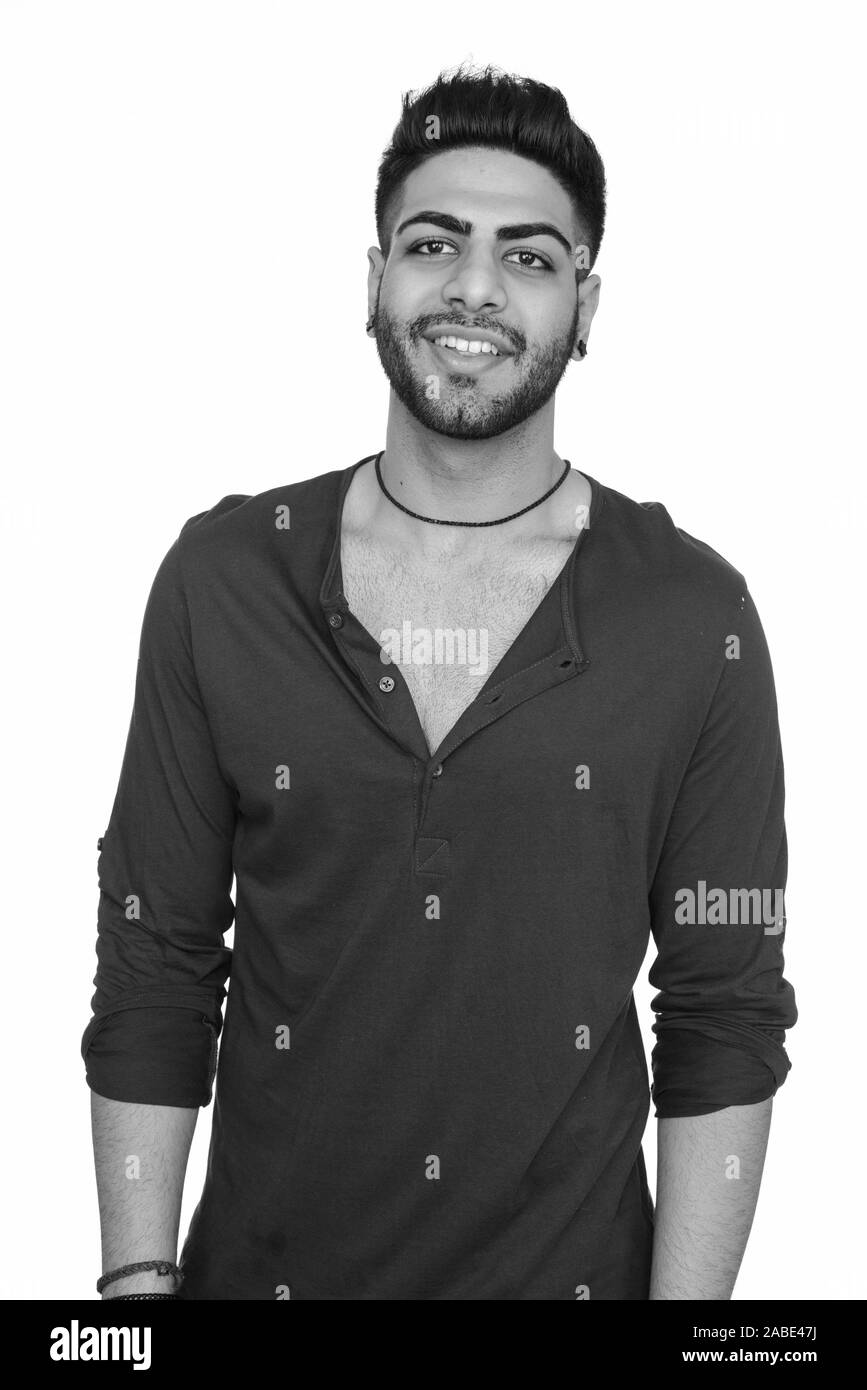 Studio shot of young happy Indian man isolated against white background ...