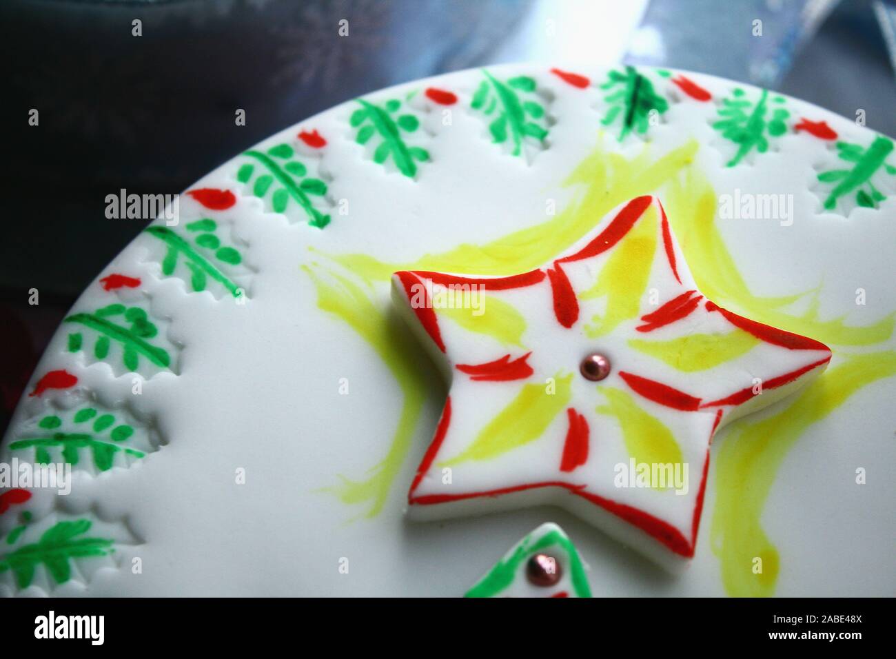 Christmas cake covered with white icing and decorated with holy, Christmas tree and a big shining star Stock Photo