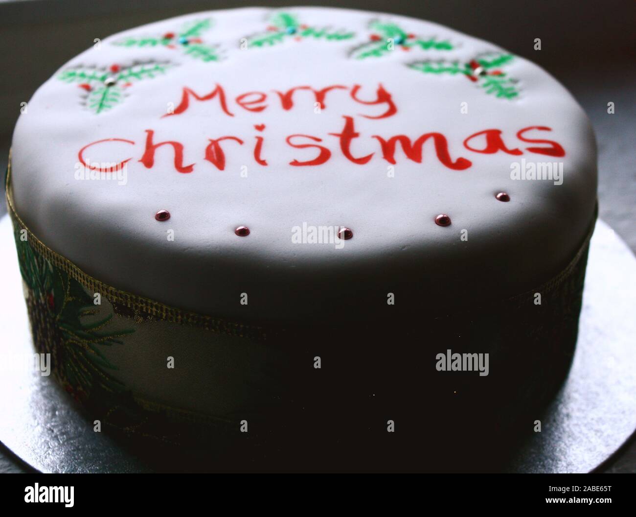 White Christmas cake with painted holy and   Merry Christmas writing on top Stock Photo