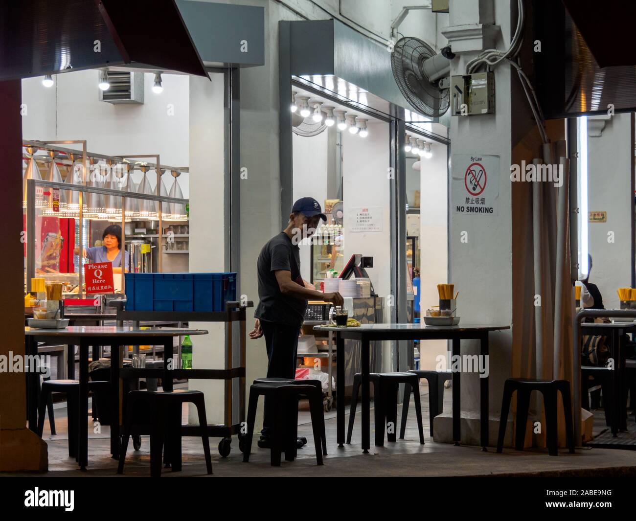 SINGAPORE - 16 MAR 2019 - A elderly Asian Chinese Singaporean male employee at a late-night eatery / coffeeshop / kopitiam enjoys a cup of coffee afte Stock Photo