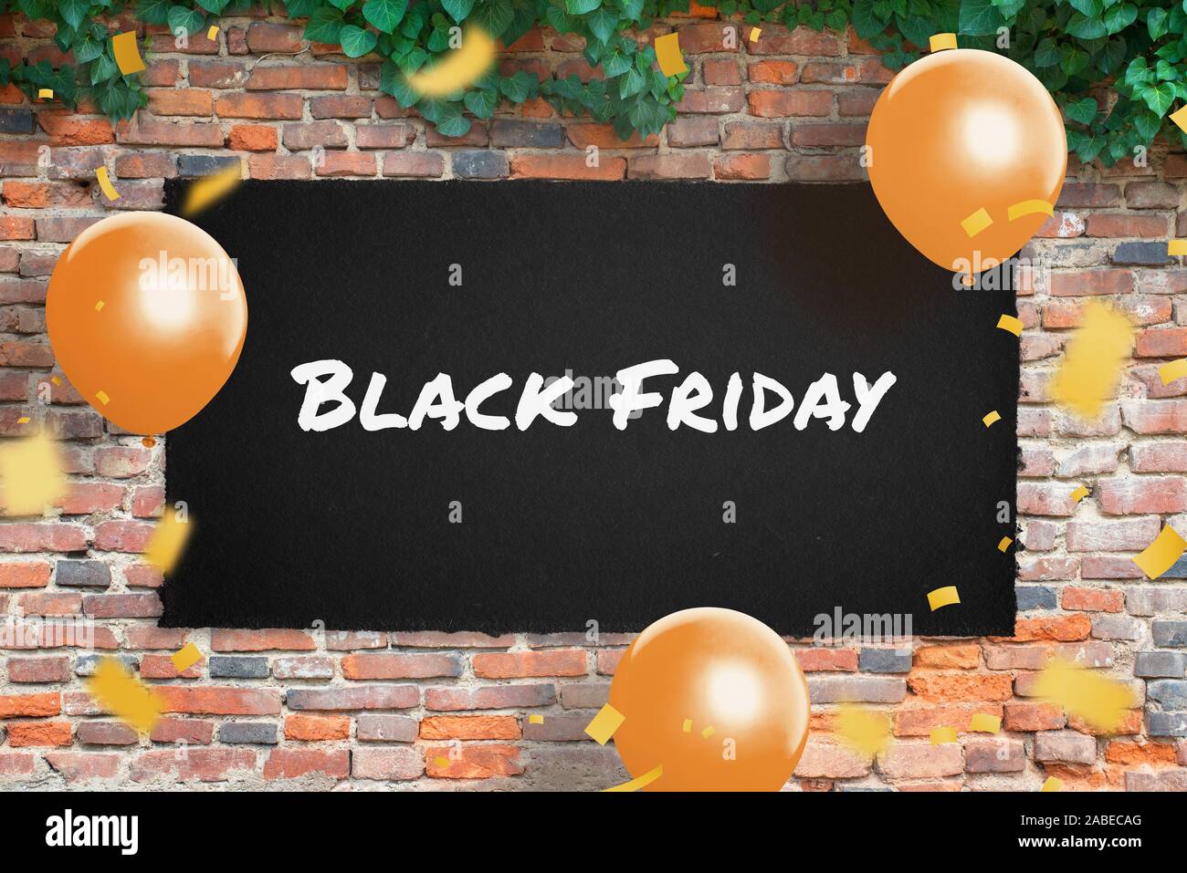 Black Friday poster on brick wall surrounded by ballons and confetti. Stock Photo
