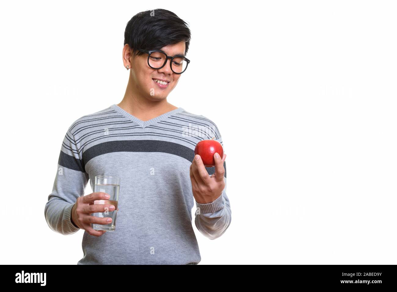 Happy Asian man smiling and looking at red apple while holding g Stock ...