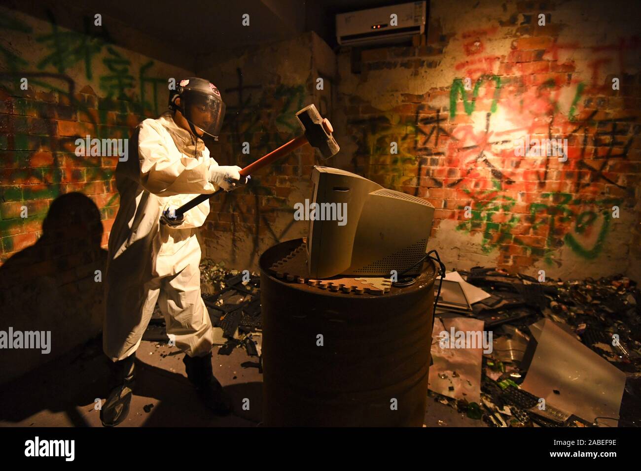 A customer uses a hammer to break a computer to release stress and negative mood at the first frustration venting room opened in Nanning city, south C Stock Photo