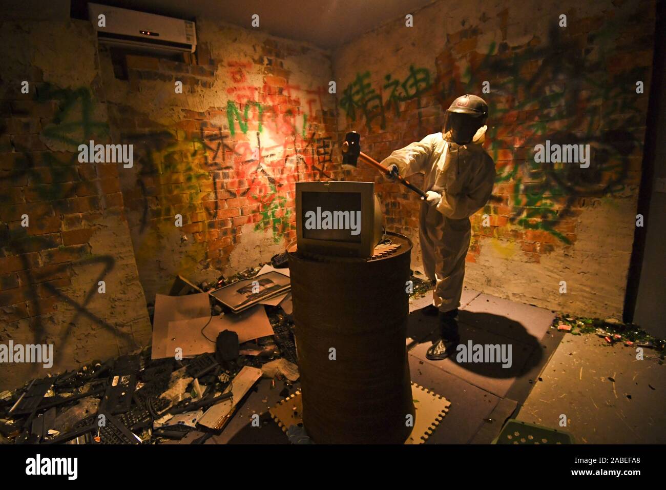 A customer uses a hammer to break a computer to release stress and negative mood at the first frustration venting room opened in Nanning city, south C Stock Photo