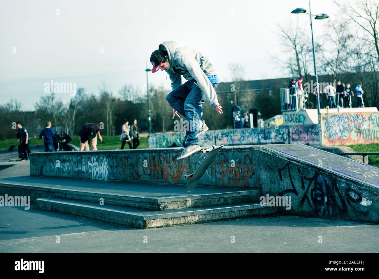 A group of professional skaters, skateboarders practicing ollieing off high steps and catching