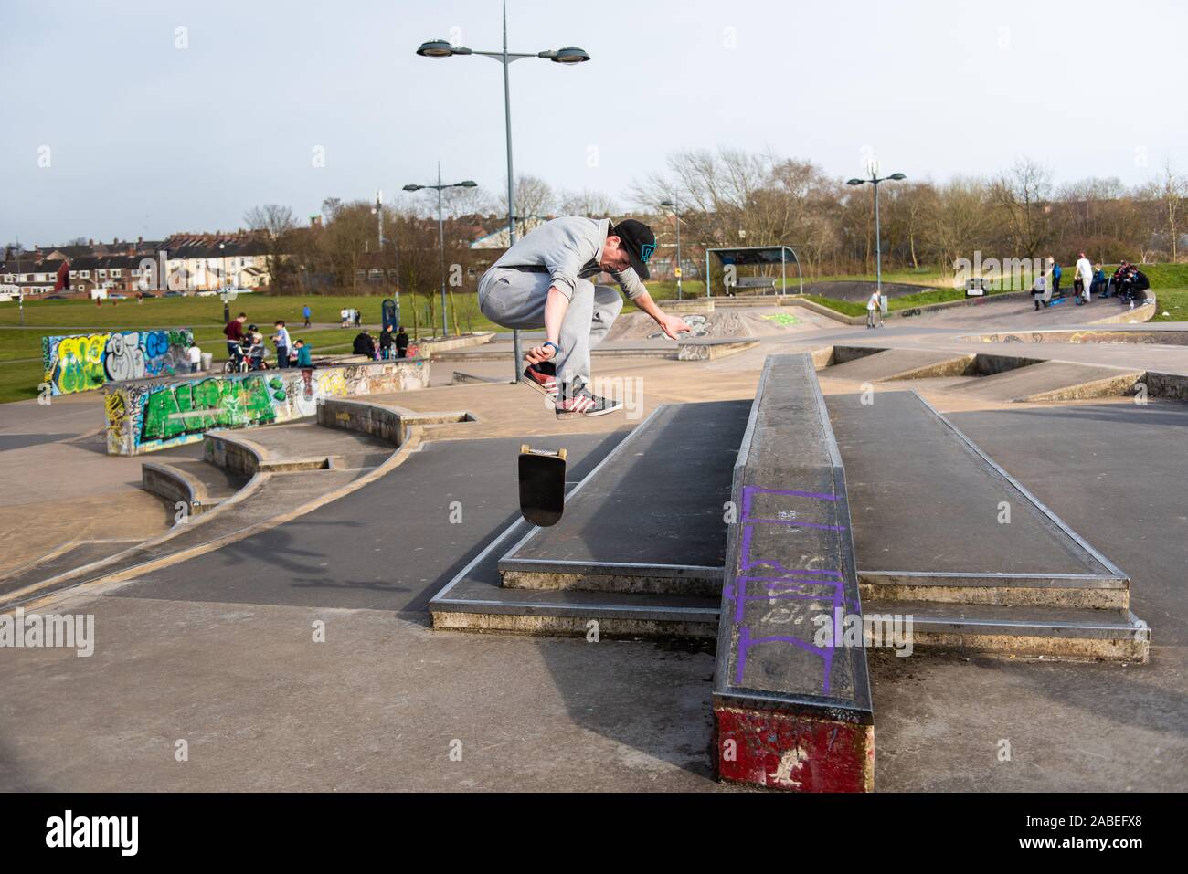 Young guys practice ollie's and tricks at the concrete skate park in