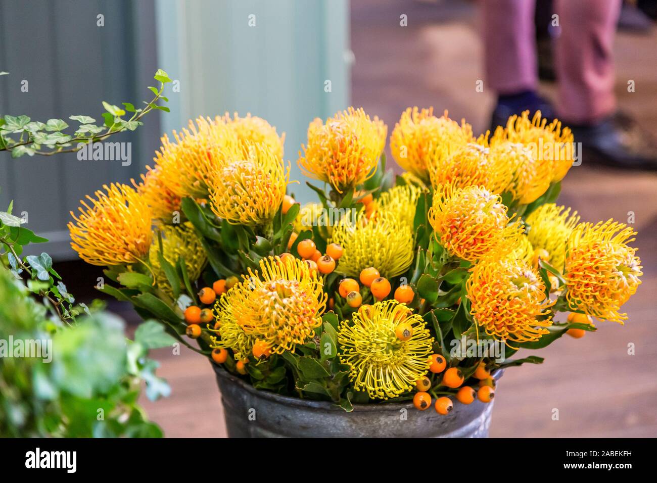 yellow fake flowers in steel bucket Stock Photo Alamy