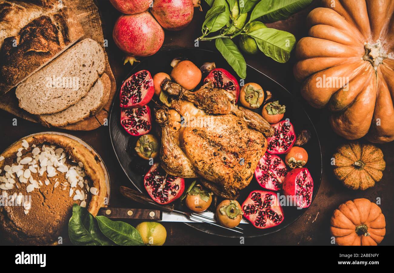 Thanksgiving table with roasted turkey and pumpkin pie, top view Stock Photo