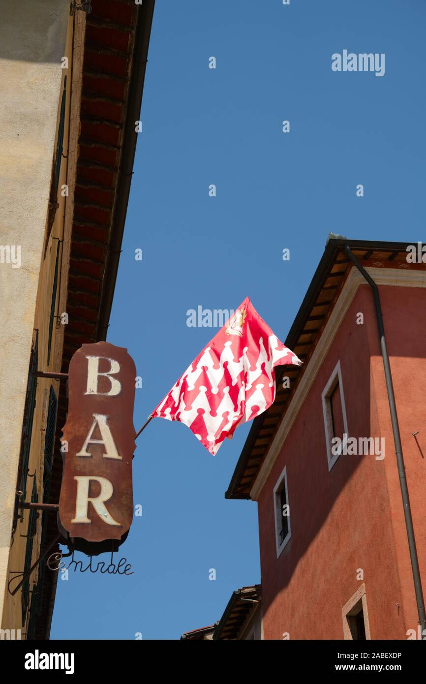 A bar sign and red and white coloured Castello Quarter flag of the Tuscan village of San Quirico d'Orcia in the Vald'Orcia Tuscany Italy Stock Photo