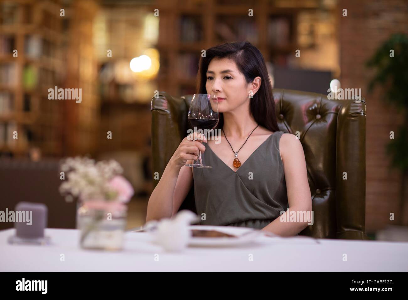 Elegant woman enjoying red wine in western restaurant Stock Photo - Alamy