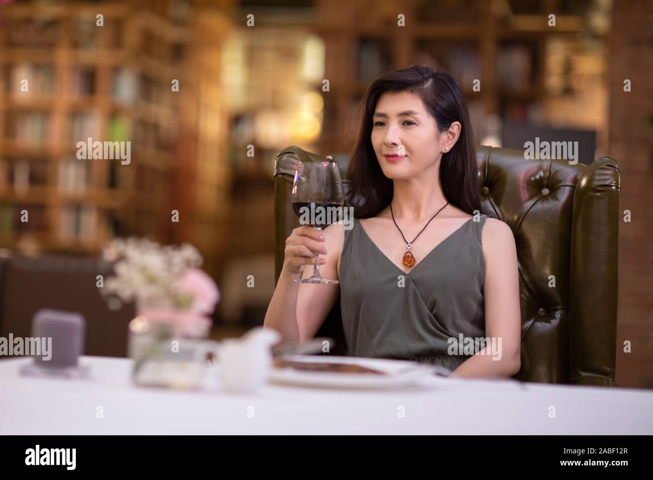 Elegant woman enjoying red wine in western restaurant Stock Photo - Alamy