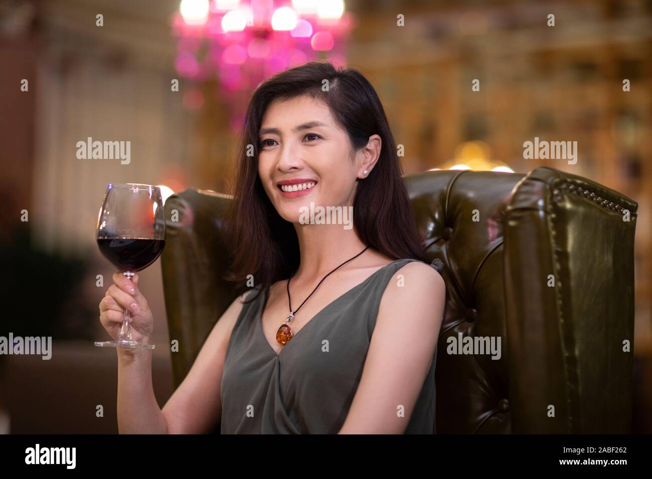 Elegant woman enjoying red wine in western restaurant Stock Photo - Alamy