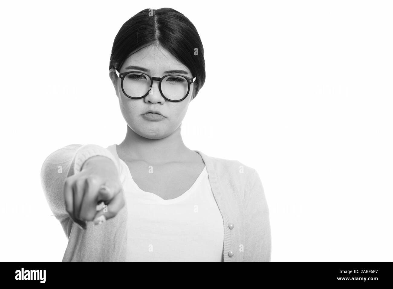 Young Asian nerd woman looking angry while pointing finger at camera Stock Photo