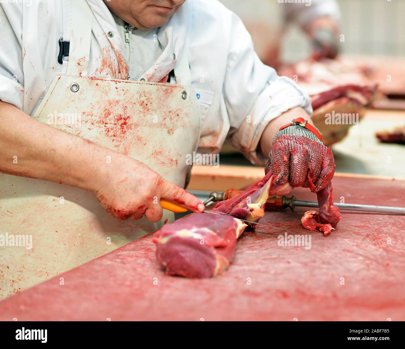 workplace food industry - factory butchery for the production of sausages - butcher cuts meat Stock Photo