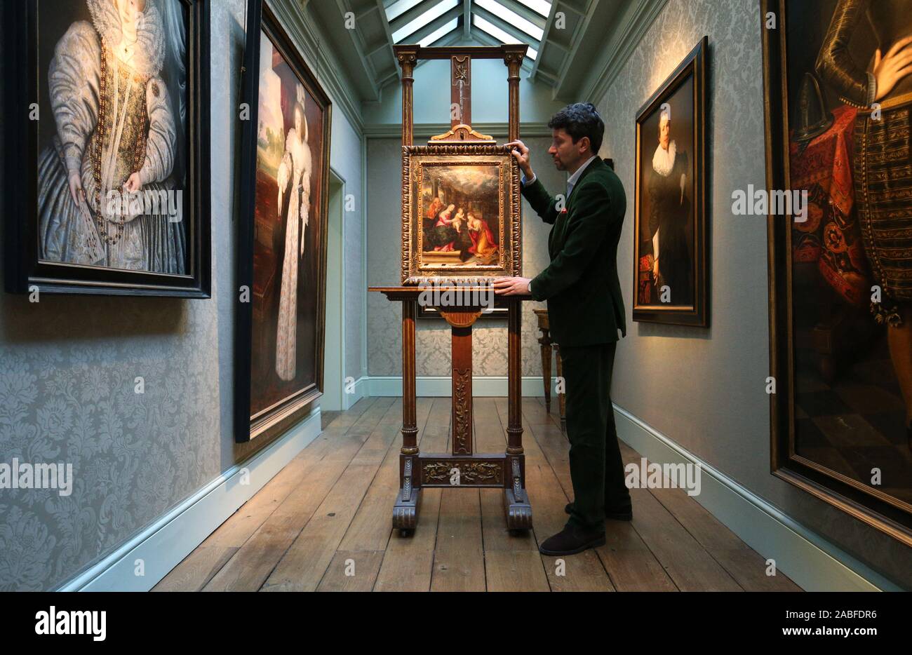 Art dealer Carlo Milano places a newly discovered work by Lavinia Fontana entitled Mystic Marriage of St. Catherine on an easel during a photo call for London Art Week at the Weiss Gallery in St James', London. Stock Photo