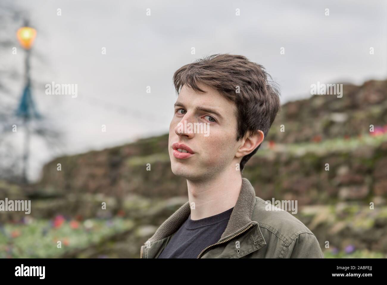 A young man in his late teens or early twenties looks questioningly at the camera as though sceptical. Stock Photo
