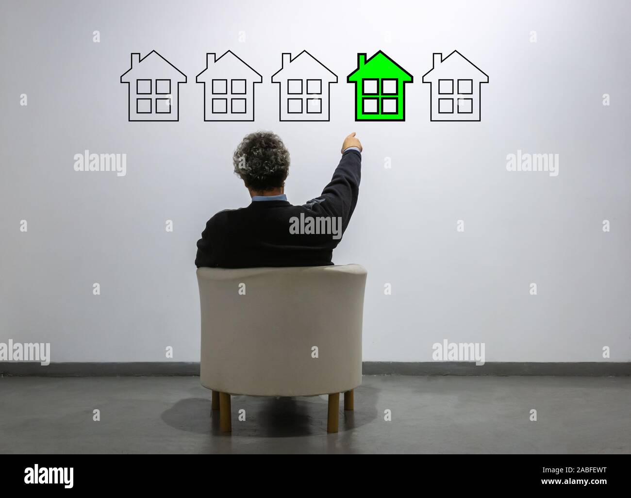 a man in front of a row of house points to a green one. concept of purchase, buying and selling, real estate Stock Photo