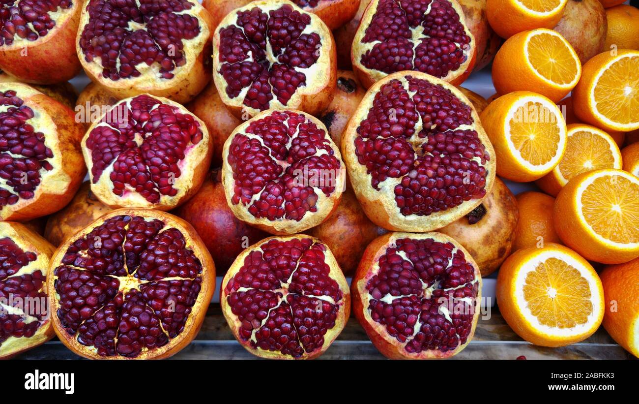 Fruit still life of pomegranates and oranges. Fresh and juicy fruits. Stock Photo