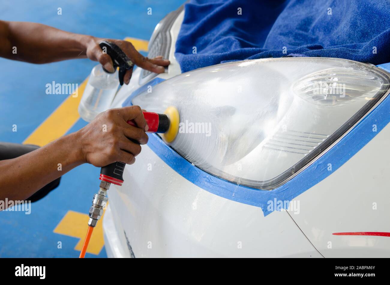 mechanic's hand is polishing the car's headlight Stock Photo Alamy